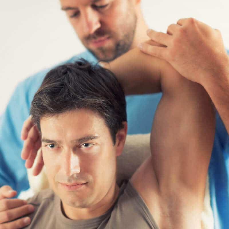 A therapist is treating the arm of a person.