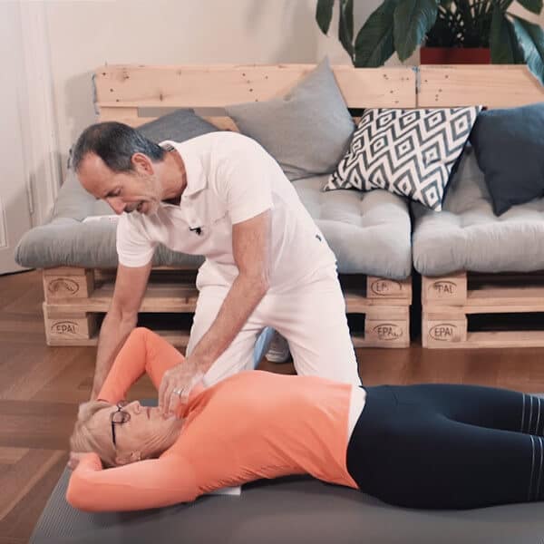 A woman is lying on her back, with her hands on her head, stretching.