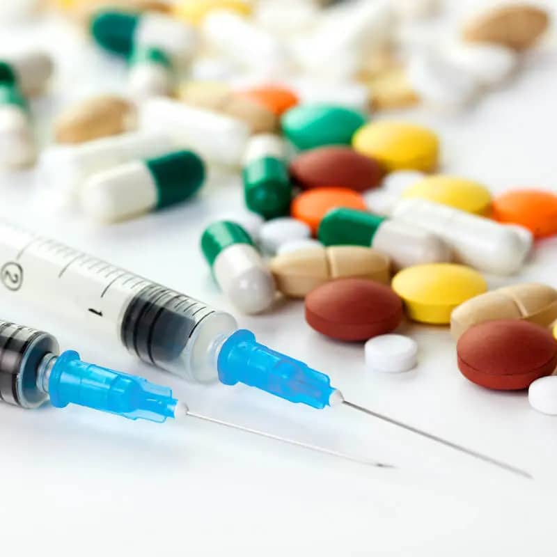 Two syringes and a handful of pills.