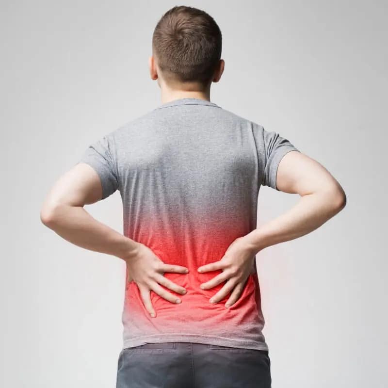 A man gripping his lower back in pain.