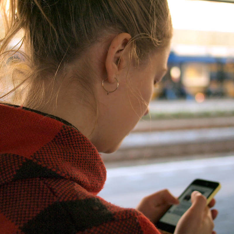 A girl is looking at her mobile phone.