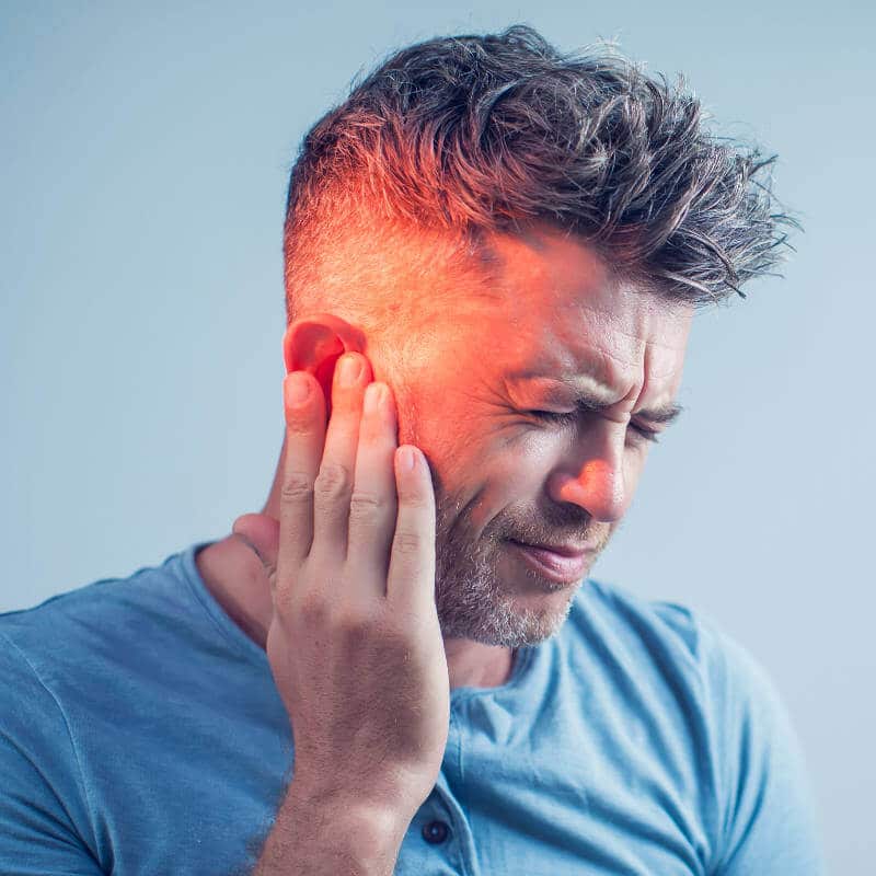 Man touching his ear and jaw in pain.