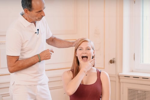 A woman stretching her jaw.