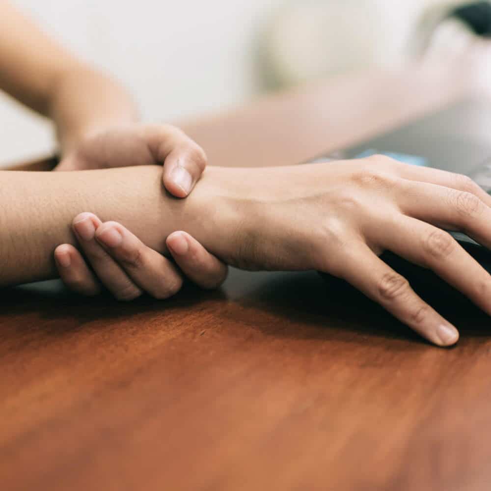 A hand grabbing the wrist of another hand.