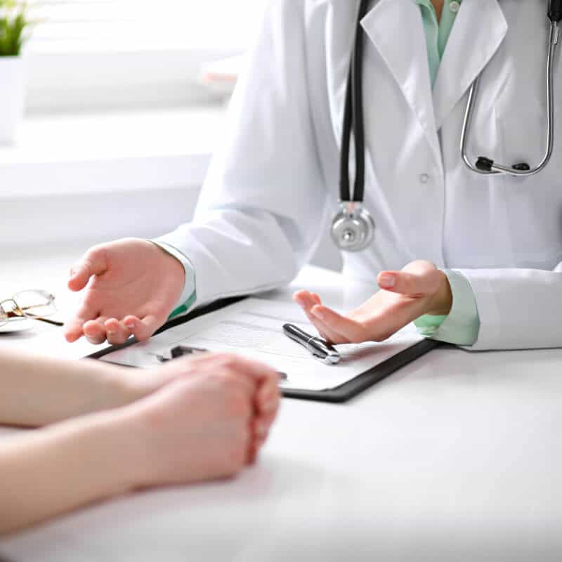 You can see a doctor gesticulating and explaining something to their patient.