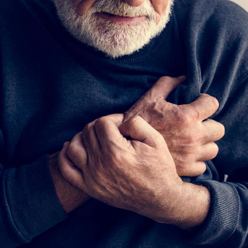 An old man clutching his chest in pain.