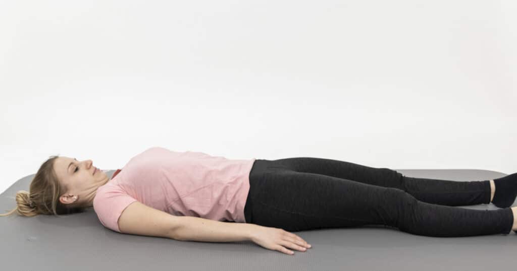 A woman is lying on her back to relax her muscles