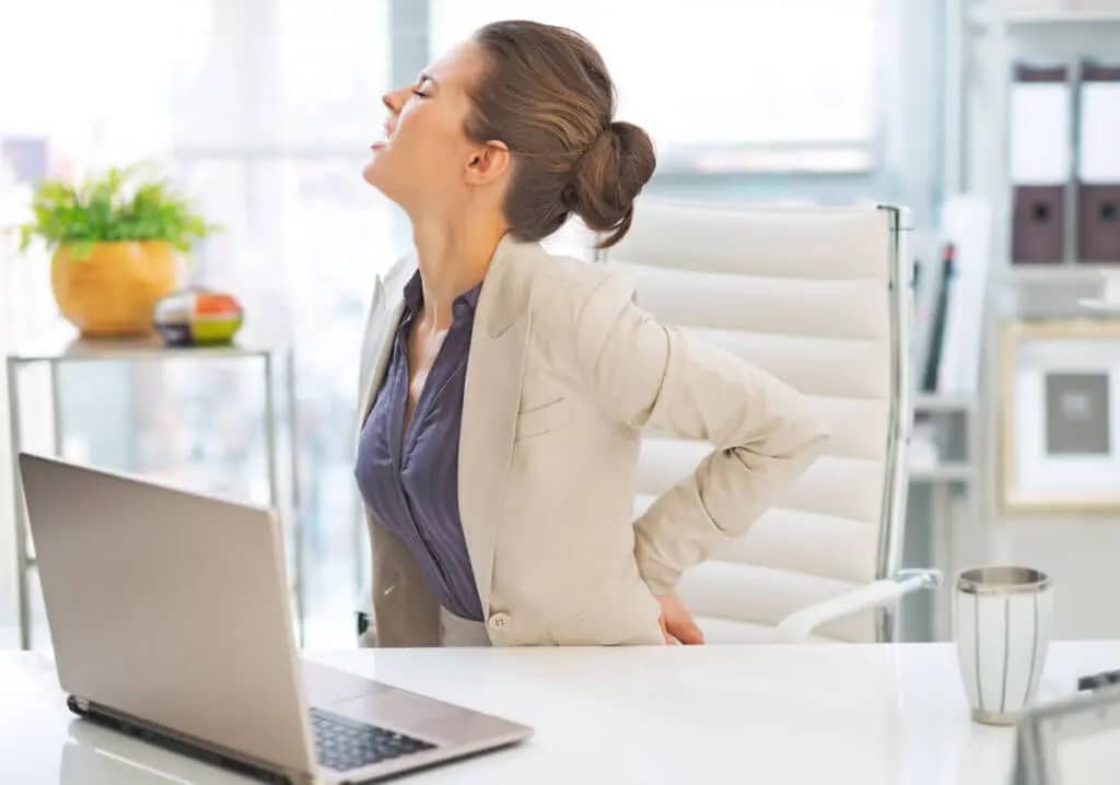A woman is clutching her aching back.