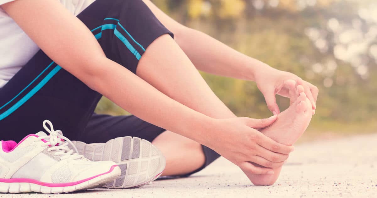 A woman rubbing her hurting foot.