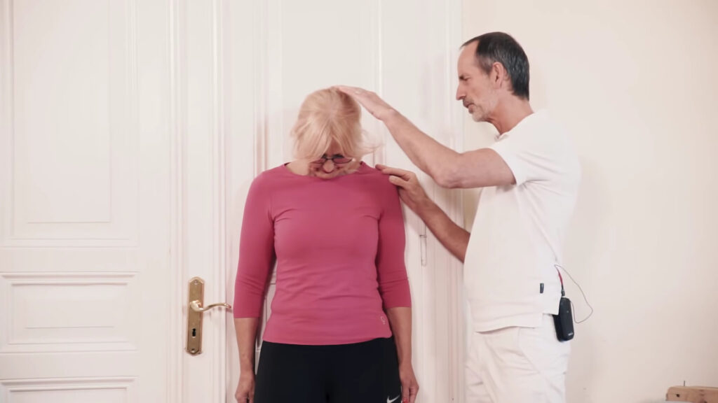 A woman is bending her head, resting her chin on her chest.