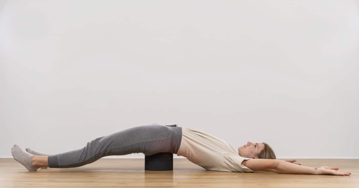 A girl is using the Back Hero to stretch her back.