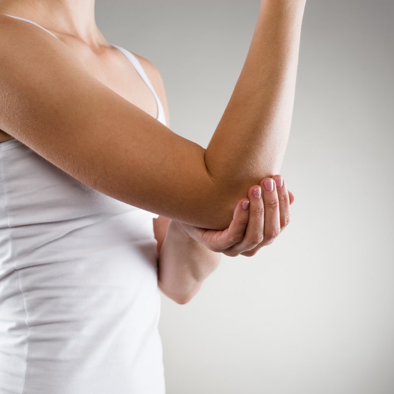 A woman is suffering tennis elbow pain.
