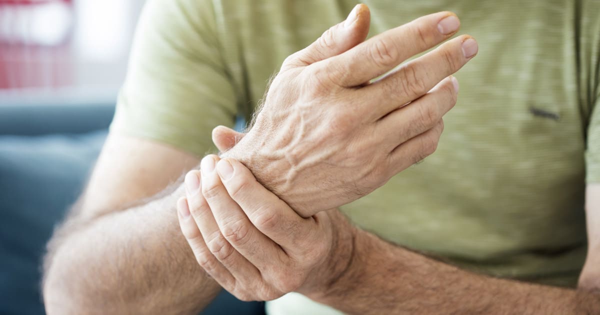 A person is clasping their tendonitis-affected wrist.
