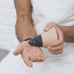 Roland Liebscher-Bracht is pressing the Osteopressure tool into his right hand