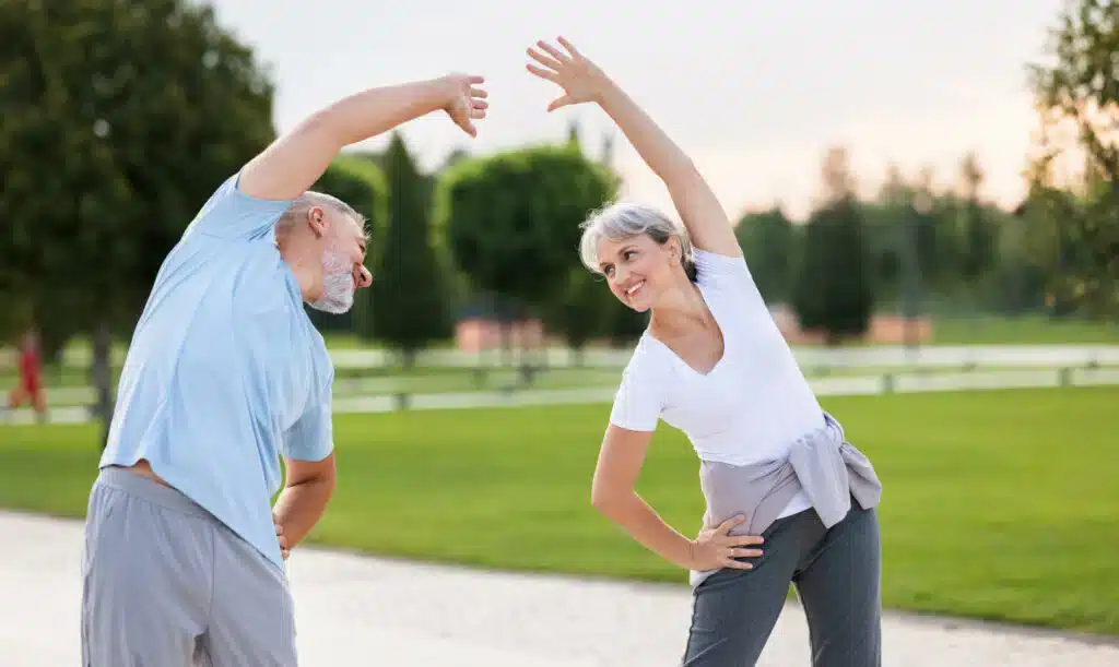 Two people stretching in a park.